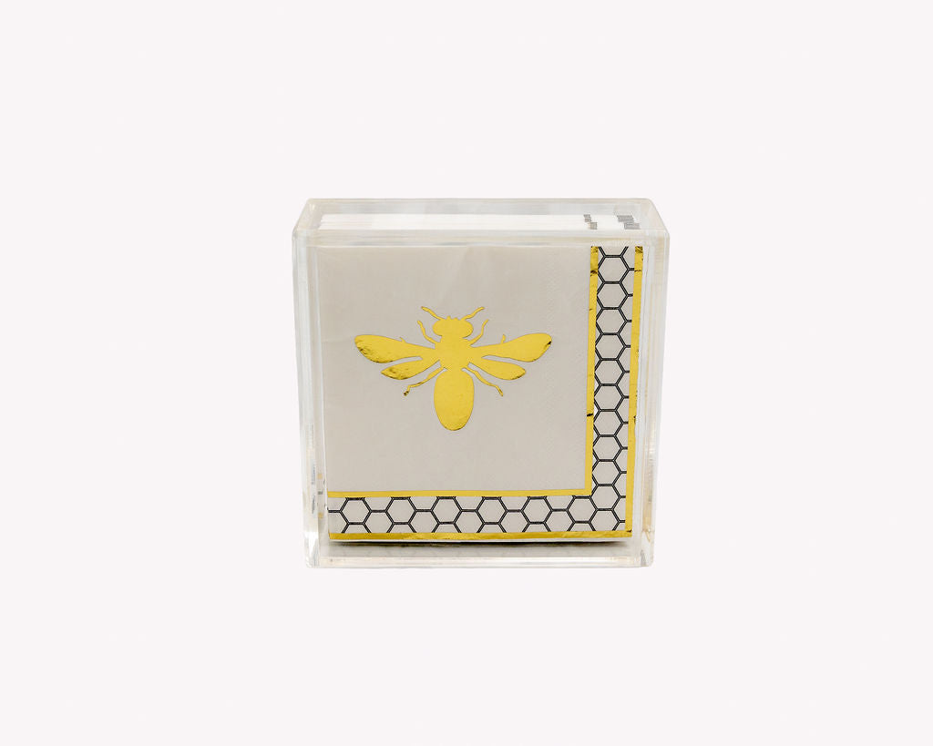 A clear acrylic block displaying a folded napkin with a yellow bumblebee design and a black and yellow honeycomb border pattern, set against a plain white background.