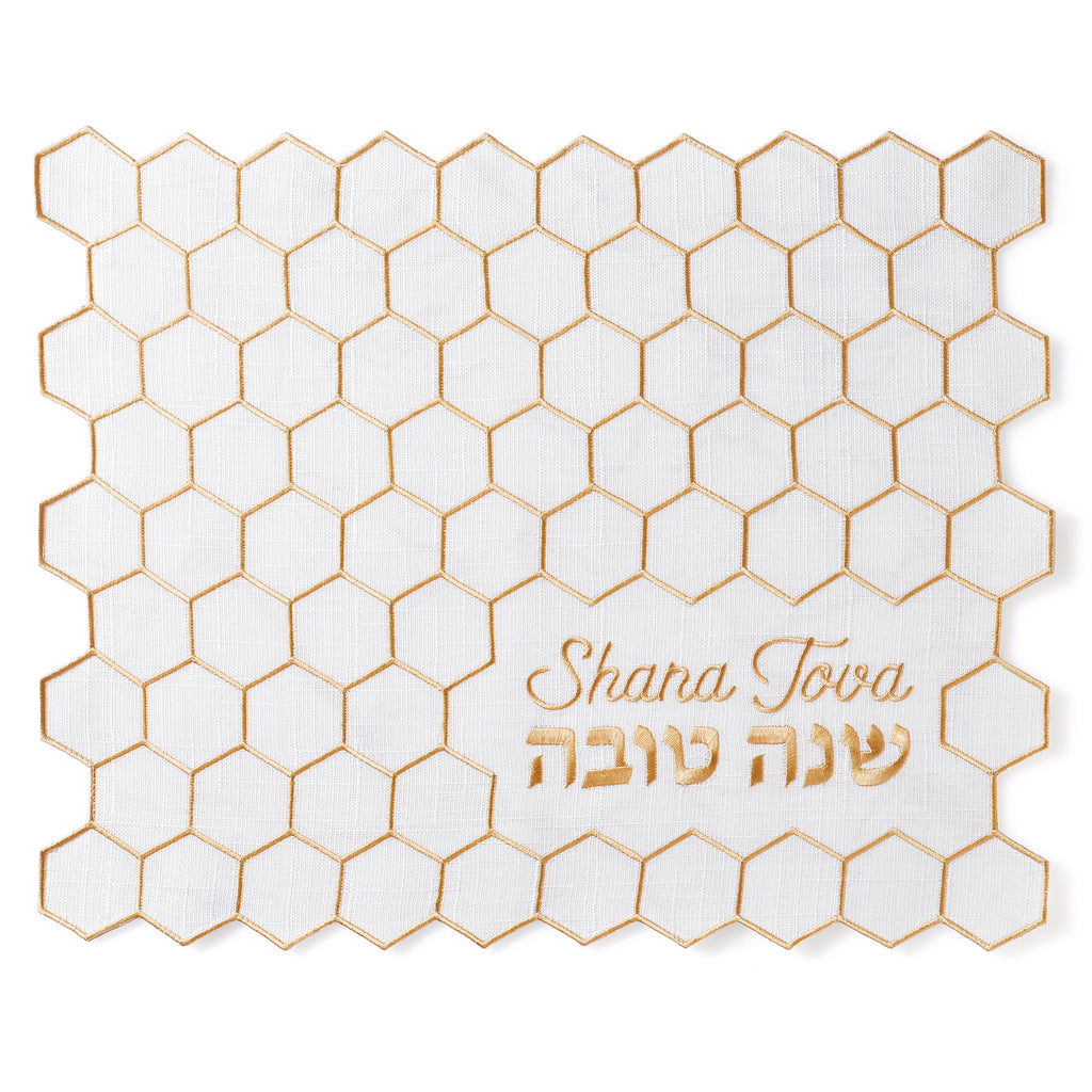 White placemat with gold hexagonal pattern and 'Shana Tova' text on a white background