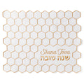 White placemat with gold hexagonal pattern and 'Shana Tova' text on a white background