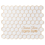 White placemat with gold hexagonal pattern and 'Shana Tova' text on a white background