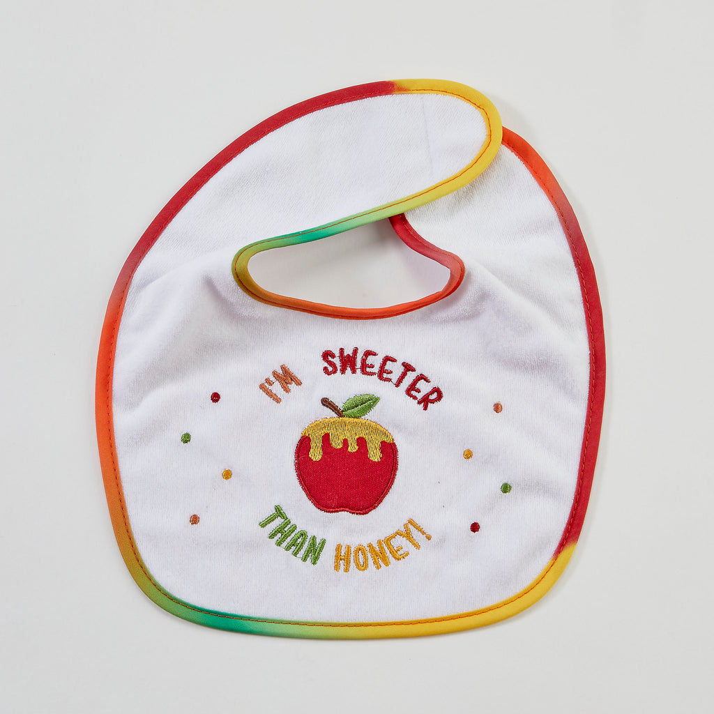 A white baby bib with a rainbow-colored stitched border and an embroidered design featuring a red apple with honey dripping from it, surrounded by the text 'I'M SWEETER THAN HONEY!'.