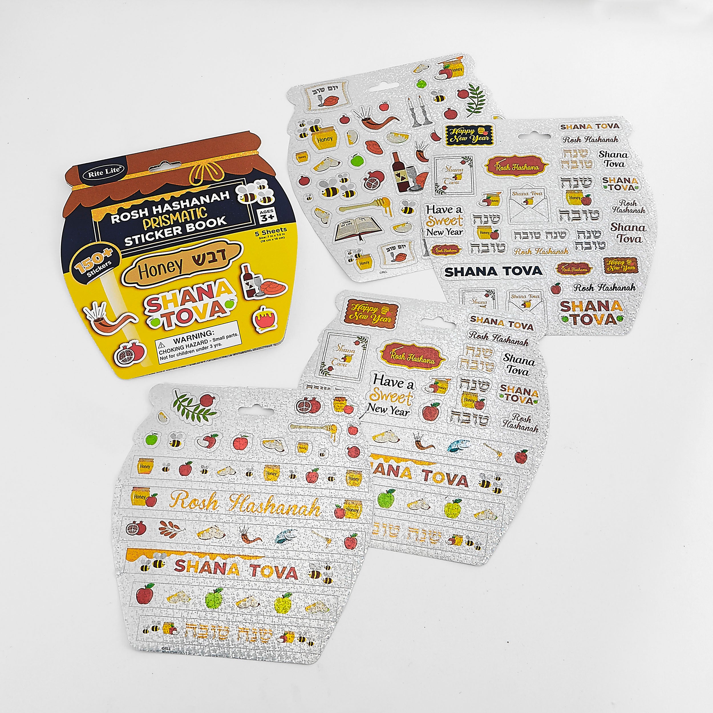A boxed sticker book for Shana Tova / Rosh Hashanah displayed with several decorated sticker sheets on a clean white background. The packaging is yellow, navy, and brown, and the sheets are white with colorful holiday illustrations and Hebrew text.
