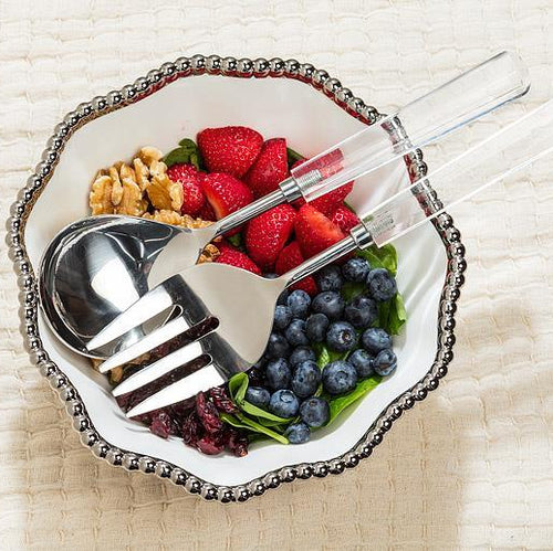 Fruit salad with berries and nuts on a decorative plate with cutlery.