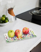 Three apples on a floral-patterned tray in a kitchen setting
