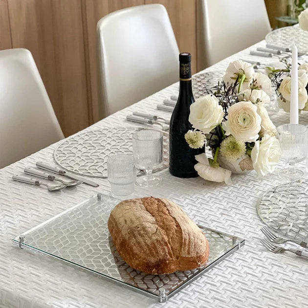 Dining table set with bread, wine, and flowers in a home setting
