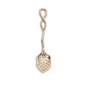 Gold-colored spoon with leaf design on a white background