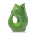 Green ceramic vase shaped like a fish on a white background
