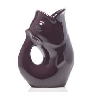 A glossy dark plum ceramic pitcher shaped like a stylized fish with a central loop hole, set against a plain white background.