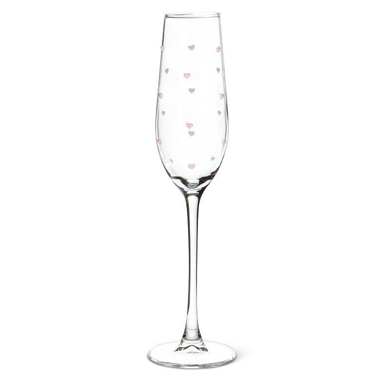 Clear champagne flute with pink heart patterns on a white background