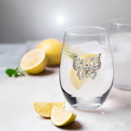 Clear glass with a decorative butterfly charm on a surface with lemons